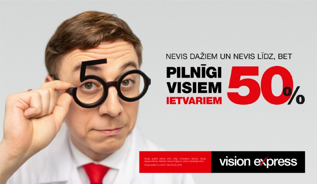 A man holding a pair of glasses with the number 50 in large font as part of the frame, creating the illusion of oversized glasses. He wears a white coat and red tie. Text in Latvian on the right says "Pilnīgi visiem ietvariem 50%". Vision Express logo is at the bottom right.